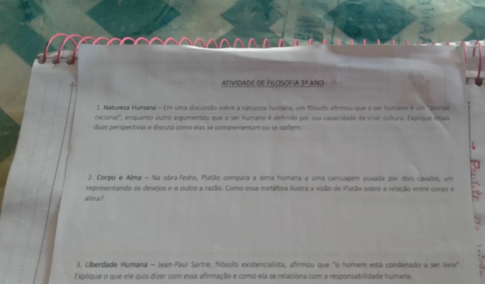 ATIVIDADE DE FILOSOFIA 3^0 ANO 
1. Natureza Humana - Em uma discussão sobre a natureza humana, um filósofo afirmou que o ser humano é um "animal 
racional', enquanto outro argumentou que o ser humano é definido por sua capacidade de criar cultura. Explique essas 
duas perspectivas e discuta como elas se complementam ou se opõem. 
2. Corpo e Alma - Na obra Fedro, Platão compara a alma humana a uma carruagem puxada por dois cavalos, um 
representando os desejos e o outro a razão. Como essa metáfora ilustra a visão de Platão sobre a relação entre corpo e 
alma ? 
3. Liberdade Humana - Jean-Paul Sartre, filósofo existencialista, afirmou que "o homem está condenado a ser livre". 
Explique o que ele quis dizer com essa afirmação e como ela se relaciona com a responsabilidade humana.