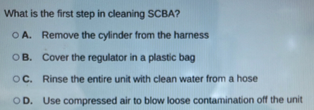 What is the first step in cleaning SCBA?
A. Remove the cylinder from the harness
B. Cover the regulator in a plastic bag
C. Rinse the entire unit with clean water from a hose
D. Use compressed air to blow loose contamination off the unit