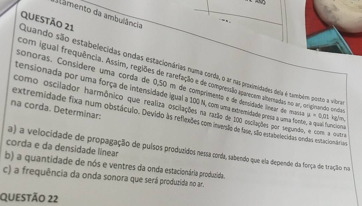 Stamento da ambulância 
QUEStÃO 21 
Quando são estabelecidas ondas estacionárias numa corda, o ar nas proximidades dela é também posto a vibra 
com igual frequência. Assim, regiões de rarefação e de compressão aparecem alternadas no ar, originando onda 
sonoras. Considere uma corda de 0,50 m de comprimento e de densidade línear de mass mu =0,01kg/m
tensionada por uma força de intensidade igual a 100 N, com uma extremidade presa a uma fonte, a qual funcioda 
como oscilador harmônico que realiza oscilações na razão de 100 oscilações por segundo, e com a outroa 
na corda. Determinar: 
extremidade fixa num obstáculo. Devido às reflexões com inversão de fase, são estabelecidas ondas estacionáriaqs 
corda e da densidade linear 
a) a velocidade de propagação de pulsos produzidos nessa corda, sabendo que ela depende da força de tração na 
b) a quantidade de nós e ventres da onda estacionária produzida. 
c) a frequência da onda sonora que será produzida no ar. 
QUeStão 22