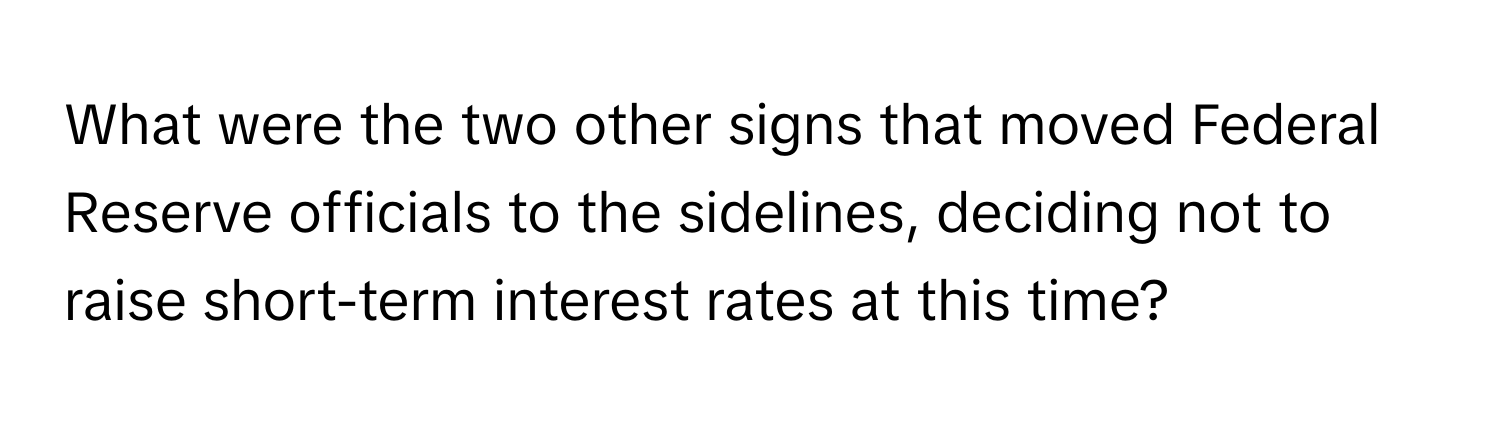 What were the two other signs that moved Federal Reserve officials to the sidelines, deciding not to raise short-term interest rates at this time?