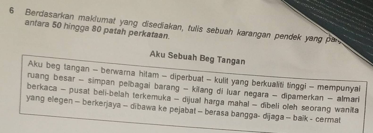 Berdasarkan maklumat yang disediakan, tulis sebuah karangan pendek yang par 
antara 50 hingga 80 patah perkataan. 
Aku Sebuah Beg Tangan 
Aku beg tangan - berwarna hitam - diperbuat - kulit yang berkualiti tinggi - mempunyai 
ruang besar - simpan pelbagai barang - kilang di luar negara - dipamerkan - almari 
berkaca - pusat beli-belah terkemuka - dijual harga mahal - dibeli oleh seorang wanita 
yang elegen - berkerjaya - dibawa ke pejabat - berasa bangga- dijaga - baik - cermat