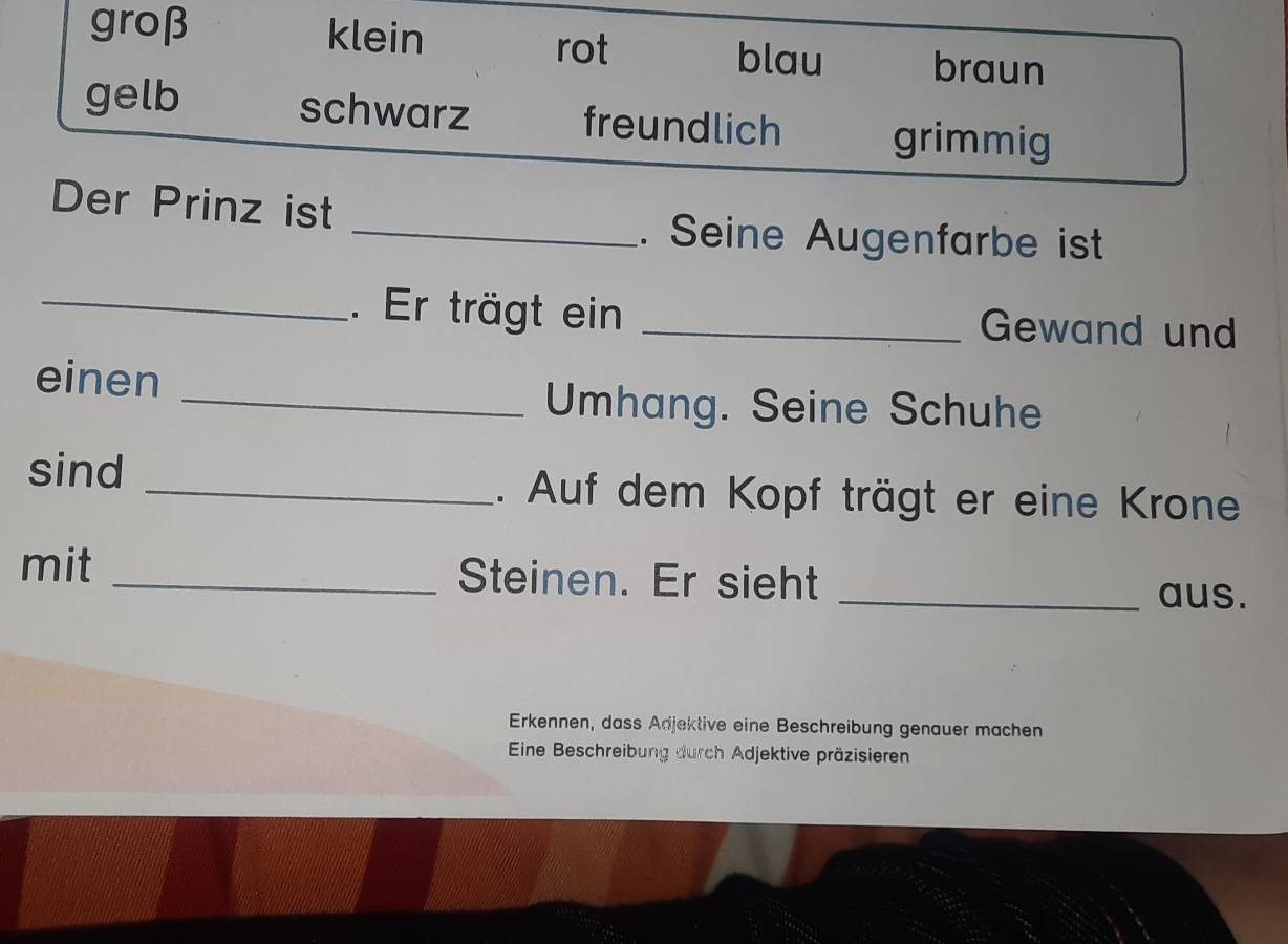 groβ klein rot blau braun
schwarz
gelb freundlich grimmig
Der Prinz ist
_. Seine Augenfarbe ist
_. Er trägt ein _Gewand und
einen
_Umhang. Seine Schuhe
sind _. Auf dem Kopf trägt er eine Krone
mit _Steinen. Er sieht _aus.
Erkennen, dass Adjektive eine Beschreibung genauer machen
Eine Beschreibung durch Adjektive präzisieren