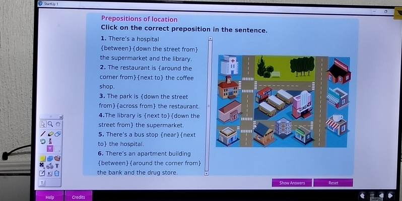 StartUp 
Prepositions of location
Click on the correct preposition in the sentence.
1. There's a hospital
between down the street from
the supermarket and the library.
2. The restaurant is around the
corner fromnext to the coffee
shop.
3. The park is down the street
fromacross from the restaurant.
4.The library is next todown the
street from the supermarket.
5. There's a bus stop nearnext
to the hospital.
6. There's an apartment building
between around the corner from
the bank and the drug store.
Show Answers Reset
Help Credits