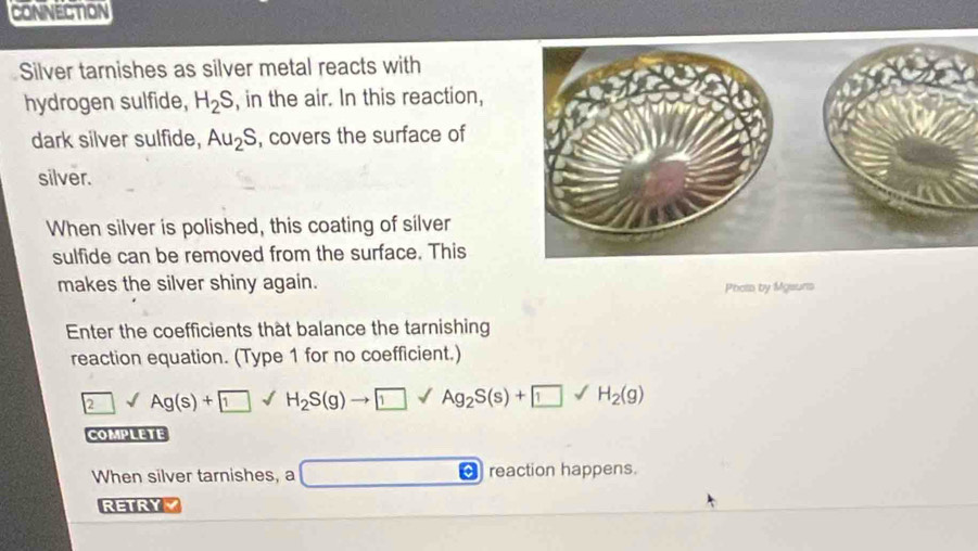 CONNECTION 
Silver tarnishes as silver metal reacts with 
hydrogen sulfide, H_2S , in the air. In this reaction, 
dark silver sulfide, Au_2S , covers the surface of 
silver. 
When silver is polished, this coating of silver 
sulfide can be removed from the surface. This 
makes the silver shiny again. 
Phois by Mgsuns 
Enter the coefficients that balance the tarnishing 
reaction equation. (Type 1 for no coefficient.)
2surd Ag(s)+ 1surd H_2S(g)to
COMPLETE 
When silver tarnishes, a □ [ reaction happens. 
RETRYY