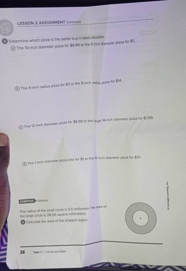 LESSON 2 ASSIGNMENT Continued 
a 
2) Determine which pizza is the better buy in each situation. 
a) The 10-inch diameter pizza for $8.99 or the 6-inch diameter pizza for $5. 
⑤ The 4-inch radius pizza for $3 or the 8-inch radius pizza for $14. 
The 12-inch diameter pizza for $6.99 or the large 14-inch diameter pizza for $7.99. 
@ The 1-inch diameter pizza bite for $1 or the 10-inch diameter pizza for $10. 
STRETCH Optional 
The radius of the small circle is 0.5 millimeter. The area of 
the large circle is 28.26 square millimeters. 
Calculate the area of the shaded region. 
26 Topic 1 》 Circles and Ratio