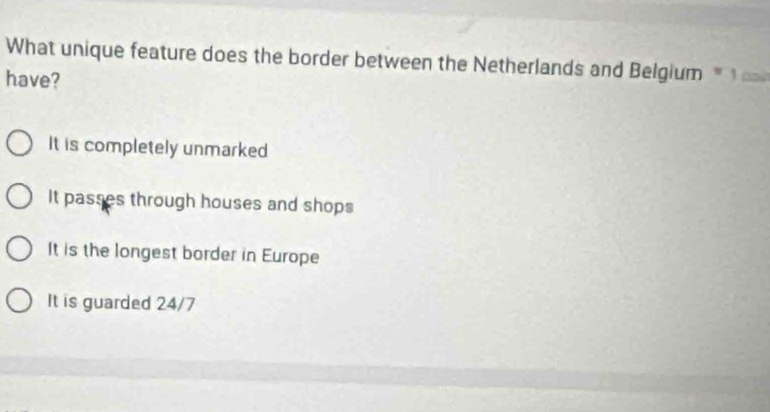 What unique feature does the border between the Netherlands and Belgium 
have?
It is completely unmarked
It passes through houses and shops
It is the longest border in Europe
It is guarded 24/7