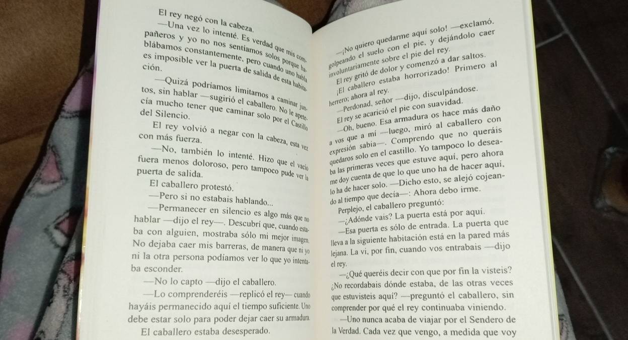 El rey negó con la cabeza.
—¡No quiero quedarme aquí solo! —exclamó.
pañeros y yo no nos sentíamos solos porque h golpeando el suelo con el pie, y dejándolo caer
Una vez lo intenté. Es verdad que mis com
blábamos constantemente, pero cuando uno hab involuntariamente sobre el pie del rey
es imposible er la puerta de salida de esta habíia El caballero estaba horrorizado! Primero al
ción.
El rey gritó de dolor y comenzó a dar saltos.
==Quizá podríamos limitarnos a caminar jun -Perdonad, señor —dijo, disculpándose.
herrero; ahora al rey.
tos, sin hablar —sugirió el caballero. No le apete El rey se acarició el pie con suavidad.
cía mucho tener que caminar solo por el Castillia Oh, bueno. Esa armadura os hace más daño
del Silencio.
a vos que a mí —luego, miró al caballero con
El rey volvió a negar con la cabeza, esta vez
con más fuerza.
sexpresión sabia—. Comprendo que no queráis
quedaros solo en el castillo. Yo tampoco lo desea-
—No, también lo intenté. Hizo que el vacio
ba las primeras veces que estuve aquí, pero ahora
fuera menos doloroso, pero tampoco pude ver h
me doy cuenta de que lo que uno ha de hacer aqui,
puerta de salida.
El caballero protestó.
lo ha de hacer solo. —Dicho esto, se alejó cojean-
—Pero si no estabais hablando...
do al tiempo que decía—: Ahora debo irme.
Perplejo, el caballero preguntó:
—Permanecer en silencio es algo más que no —¿Adónde vais? La puerta está por aquí.
hablar —dijo el rey—. Descubrí que, cuando esta- —Esa puerta es sólo de entrada. La puerta que
ba con alguien, mostraba sólo mi mejor imagen. lleva a la siguiente habitación está en la pared más
No dejaba caer mis barreras, de manera que ni yo lejana. La vi, por fin, cuando vos entrabais —dijo
ni la otra persona podíamos ver lo que yo intenta-
ba esconder. el rey.
—No lo capto —dijo el caballero. —¿Qué queréis decir con que por fin la visteis?
No recordabais dónde estaba, de las otras veces
—Lo comprenderéis —replicó el rey— cuando que estuvisteis aquí? —preguntó el caballero, sin
hayáis permanecido aquí el tiempo suficiente. Uno comprender por qué el rey continuaba viniendo.
debe estar solo para poder dejar caer su armadura. —Uno nunca acaba de viajar por el Sendero de
El caballero estaba desesperado. la Verdad. Cada vez que vengo, a medida que voy