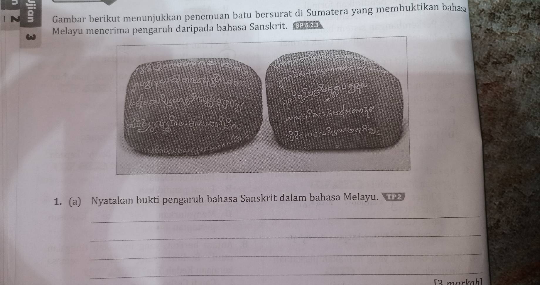 Gambar berikut menunjukkan penemuan batu bersurat di Sumatera yang membuktikan bahasą 
Melayu menerima pengaruh daripada bahasa Sanskrit. SP 5.2.3
1. (a) Nyatakan bukti pengaruh bahasa Sanskrit dalam bahasa Melayu. TP2 
_ 
_ 
_ 
_ 
[3 markah]